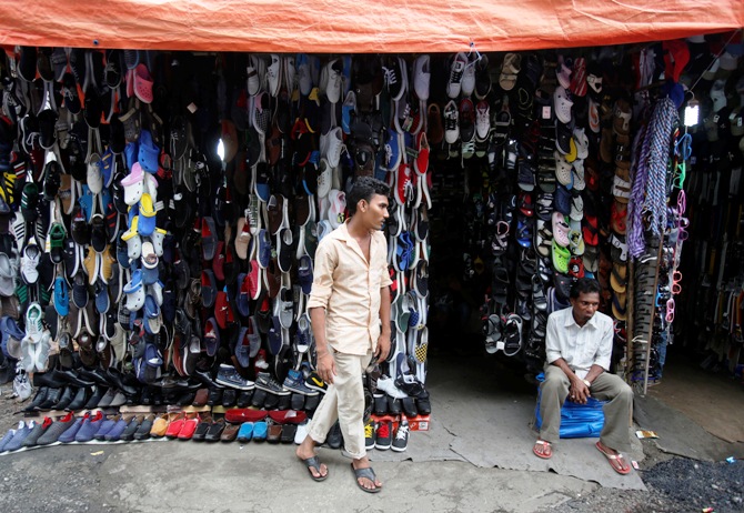 Salesmen wait for customers at a footwear store outside a shopping arcade in Mumbai.