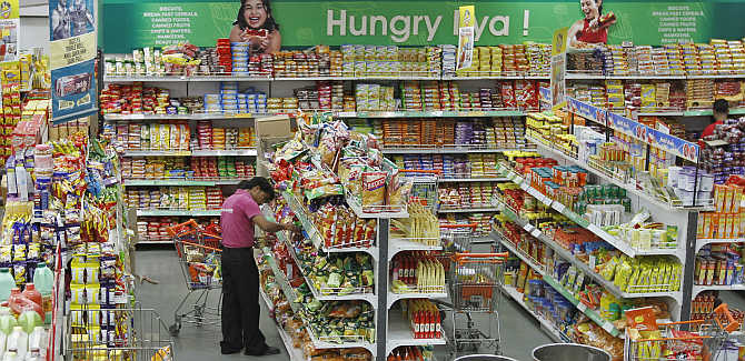 A worker of a food superstore arranges products inside a mall in Ahmedabad.