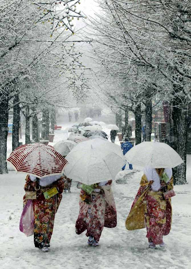 Japanese women in kimonos walk during heavy snowfall at Toshimaen amusement park in Tokyo.