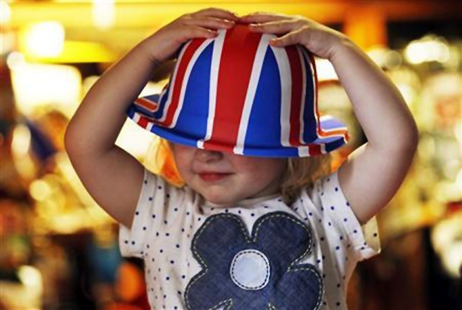 A young girl named Scarlett Rose Green tests a Union flag bowler hat in south west London.