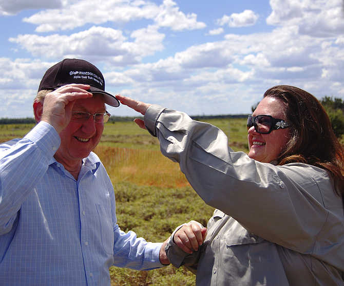 Gina Rinehart, right, adjusts a cap on the head of Australia's Minister for Resources, Energy and Tourism, Martin Ferguson in the Galilee Basin about 800km northwest of Brisbane.