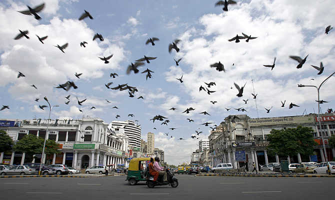 Pigeons fly as clouds gather over New Delhi's Connaught Place in India.