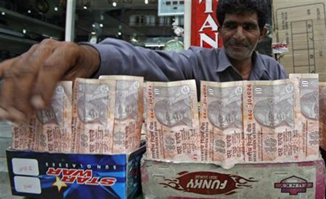 A Kashmiri money changer Nissar Ahmad displays Indian rupee notes in Srinagar.