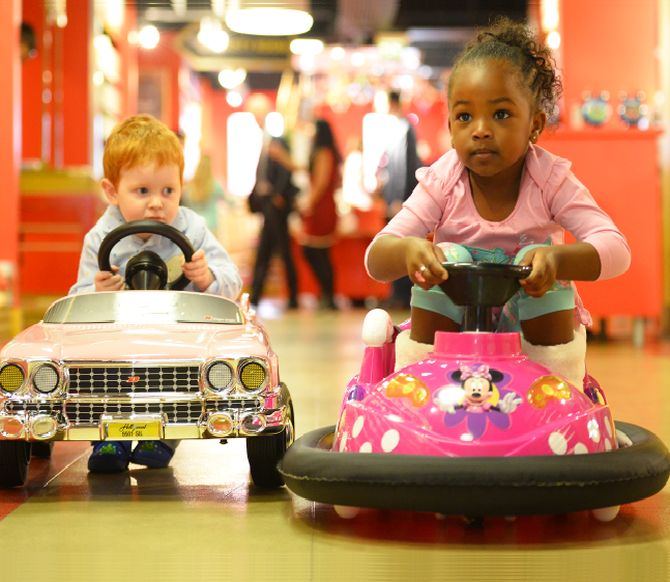 Tristan Robertson Jeyes, 2, drives a 250 pounds Sterling (383 US dollar) pink Cadillac next to Jayla Silva, 3, on a 160 pounds Sterling (244 US dollars) mini dodgem in Hamleys toy store.