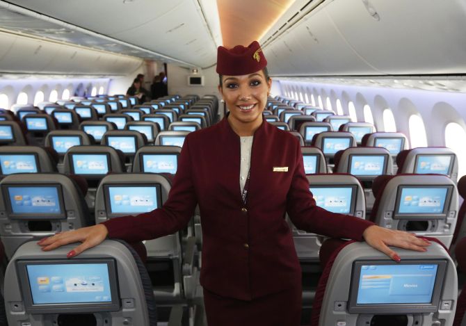 An air stewardess for Qatar Airways poses in the economy class cabin of the new Boeing 787 Dreamliner at the Farnborough Airshow.