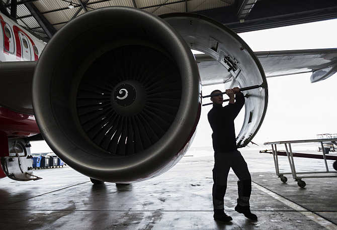 A technician opens the cover of a jet engine of an Air Berlin plane at a hangar at Tegel Airport in Berlin, Germany.