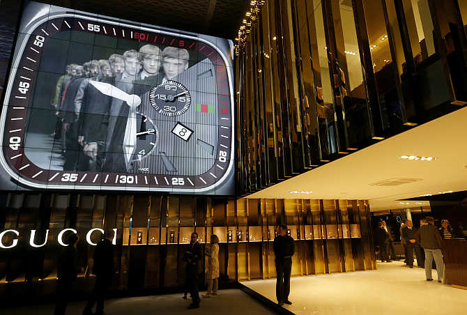 People walk at the exhibition stand of Gucci at Baselworld fair in Basel, Switzerland.