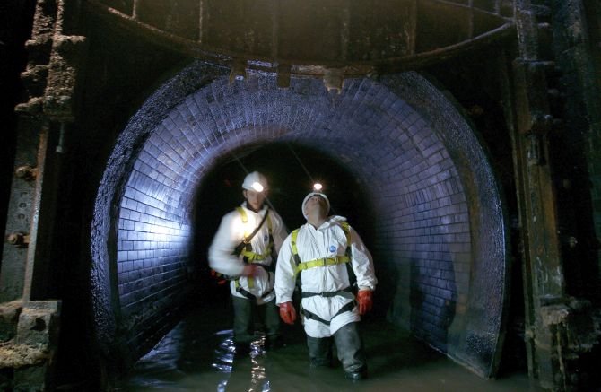Sewer inspectors, known as flushers, demonstrate looking for damage and leaks in the sewerage system during a media facility, London.