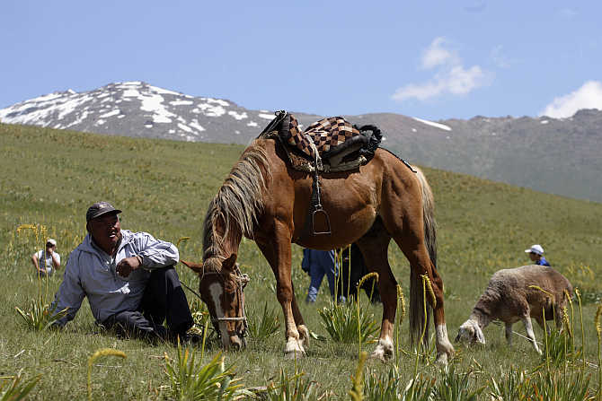 A man and his horse rest in Susamyr, Kyrgyzstan.