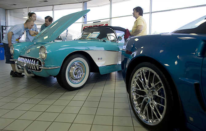 Mary Lou Gilbert, right, talks to car show attendees who are inspecting her restored 1957 Chevrolet Corvette, left, at an antique car show in Silver Spring, Maryland, United States.