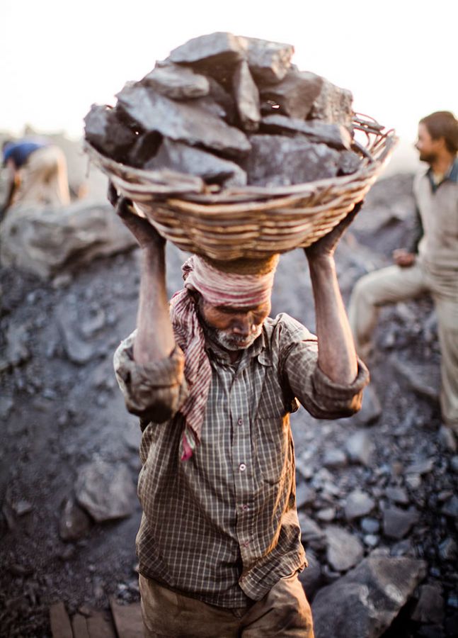 A villager carries a basket of coal scavenged illegally from an open-cast mine in the village of Jina Gora near Jharia, India. 