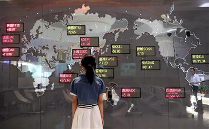A girl looks at a board showing global stock indices at the Taiwan Stock Exchange in Taipei.