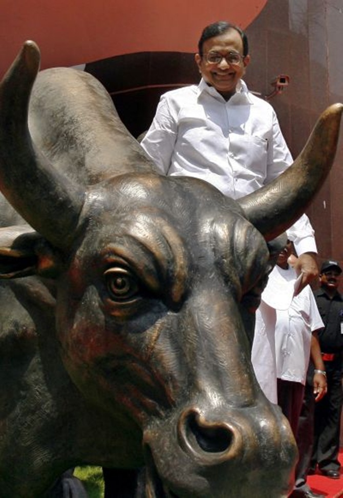 Finance Mnister P Chidambaram next to the bronze statue of a bull outside the Bombay Stock Exchange.