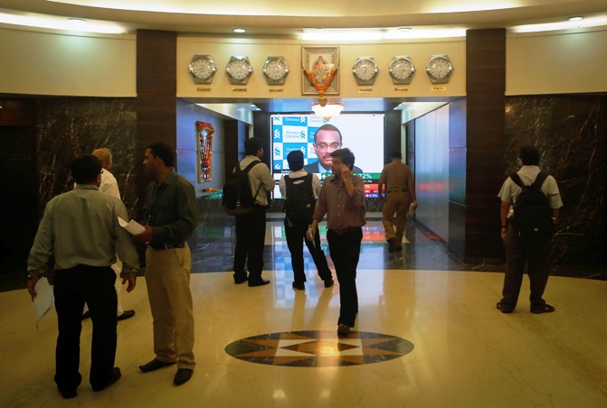 Employees stand in a lobby as they wait for the elevator inside Bombay Stock Exchange building in Mumbai.