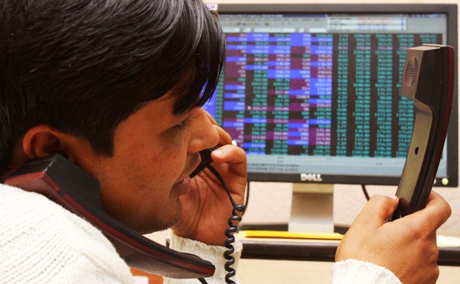 A terminal operator speaks on telephones at a local stock market in Chandigarh.