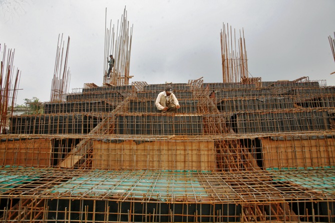 Labourers work at the construction site of a stadium on the outskirts of Agartala.