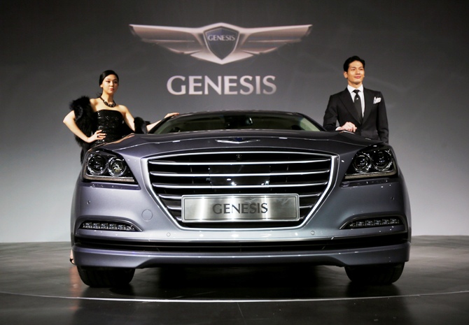 Models pose with Hyundai Motor's new Genesis sedan during a photo session at a hotel in Seoul, November 26, 2013.