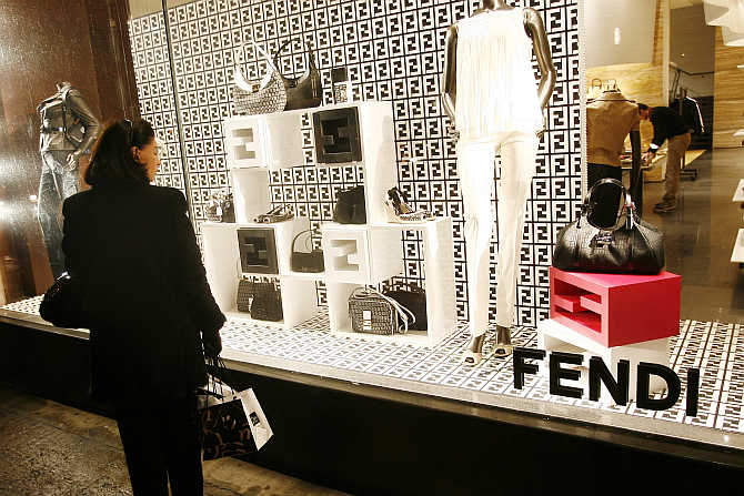 A woman looks in the window of the Fendi store in New York, United States.