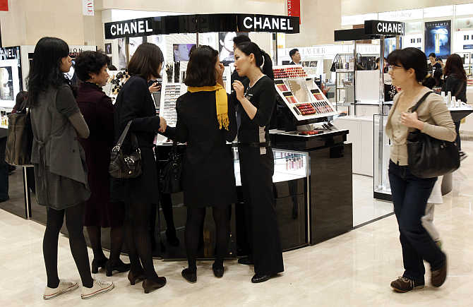 Customers choose cosmetics at a Chanel counter at the Shinsegae department store in Seoul, South Korea.