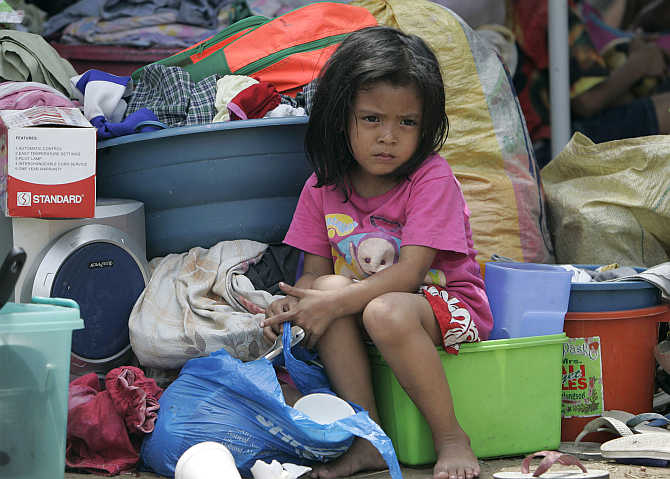 A girl sits on her belongings after a fire razed hundreds of houses and left more than a thousand families homeless at a slum area in Mandaluyong City in Manila, the Philippines.