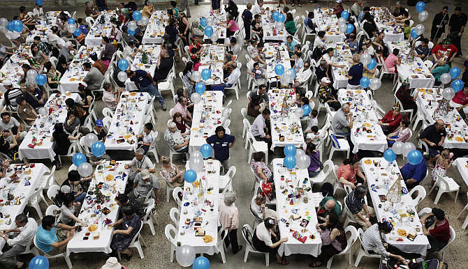 People sit down for a Christmas Day lunch served by more than 200 volunteers at a converted train workshop in Sydney, Australia. The lunch, organised by The Salvation Army and open to anyone who wished to attend, fed and entertained hundreds of elderly citizens, disadvantaged families and homeless people.