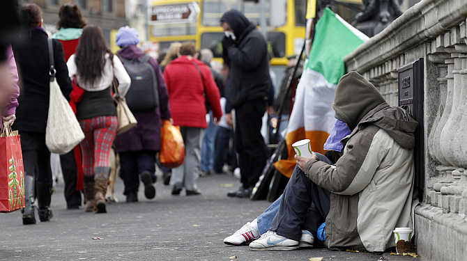 Homeless people beg for money on O'Connell bridge in central Dublin, Ireland.