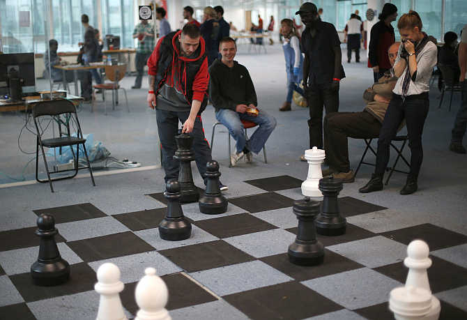 A guest plays chess with a volunteer, right, in a temporary Christmas shelter for homeless people in east London, United Kingdom.