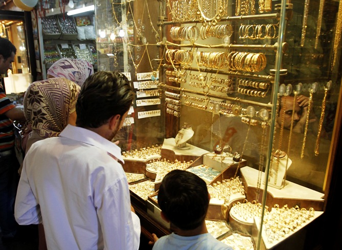 Customers stand in front of a gold shop.
