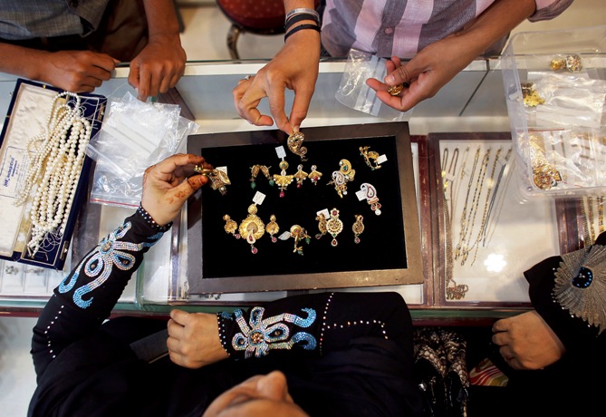 A customer looks at a gold pendent inside a jewellery showroom in Mumbai. 