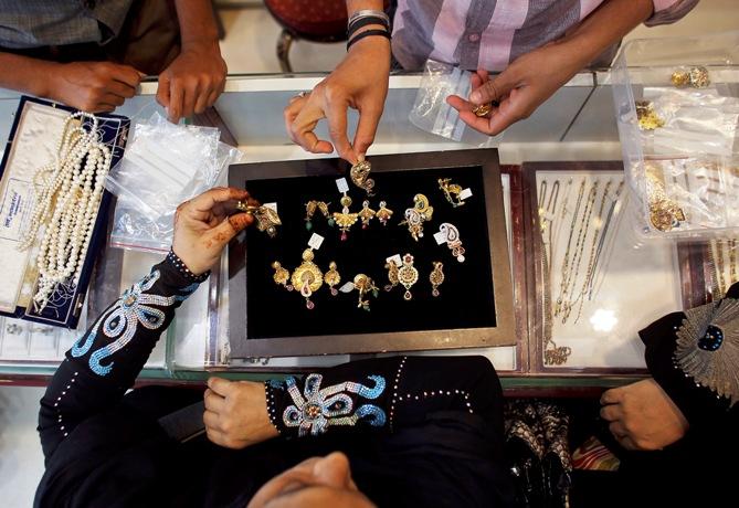 A customer looks at a gold pendent inside a jewellery showroom in Mumbai. 