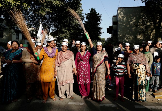 Supporters of newly formed Aam Aadmi Party, hold brooms, the party's symbol, and shout during a rally ahead of the state elections in New Delhi.