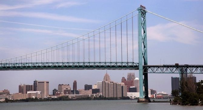 The Detroit city skyline is seen behind the Ambassador Bridge, an international border-crossing linking Windsor, Ontario with Detroit, along the Detroit River in Detroit, Michigan.