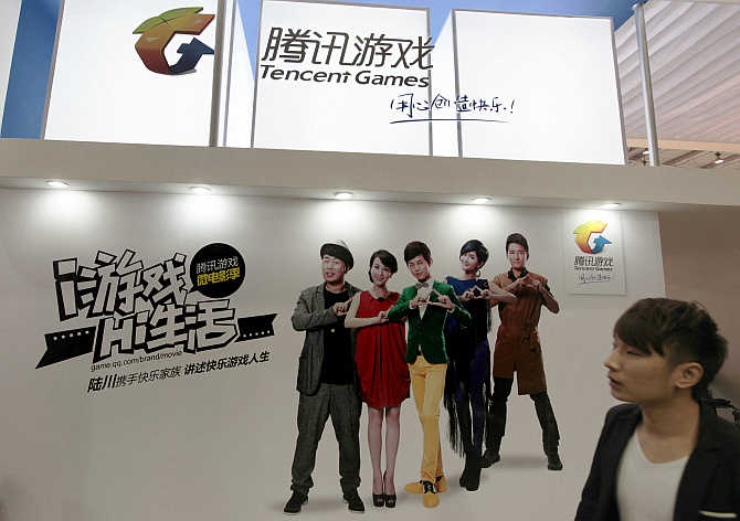 A man walks past a booth of Tencent Games during the China International Digital Content Expo in Beijing.