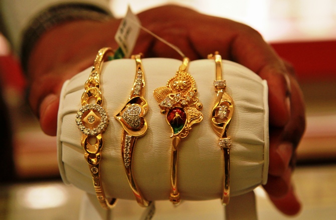 The salesman displays gold bangles to a customer at a jewellery showroom in Chennai.