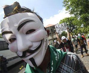 A protester from the Youth Movement of Indonesia Caravan wearing a Guy Fawkes mask gets ready to take to the streets along with other protesters ahead of the ninth World Trade Organization (WTO) Ministerial Conference in Denpasar, on the Indonesian resort island of Bali December 3, 2013. Photograph: Edgar Su/Reuters