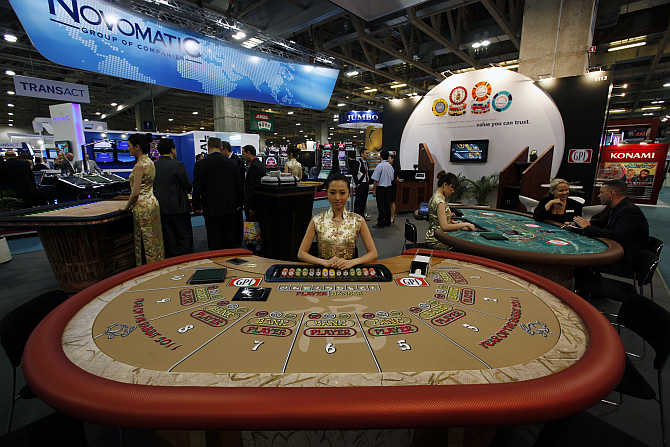 A croupier sits in front of a gaming table at Global Gaming Expo Asia in Macau.