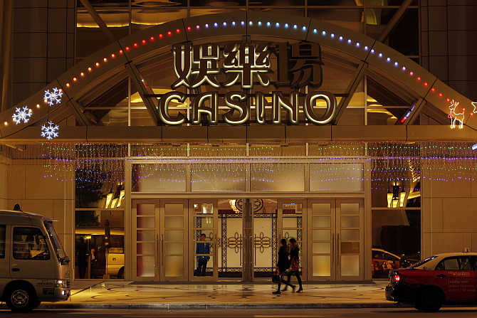 People walk past an entrance to a casino in Macau.