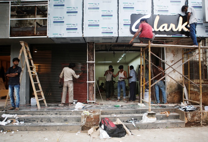 Men work at the site of a new shoe store.
