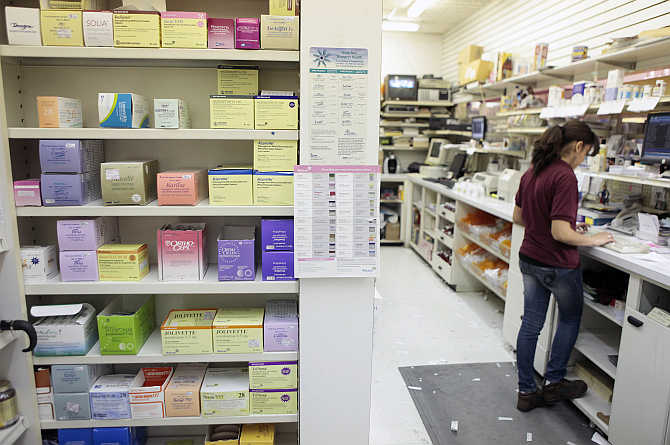 An employee enters client information while working at a pharmacy in New York.