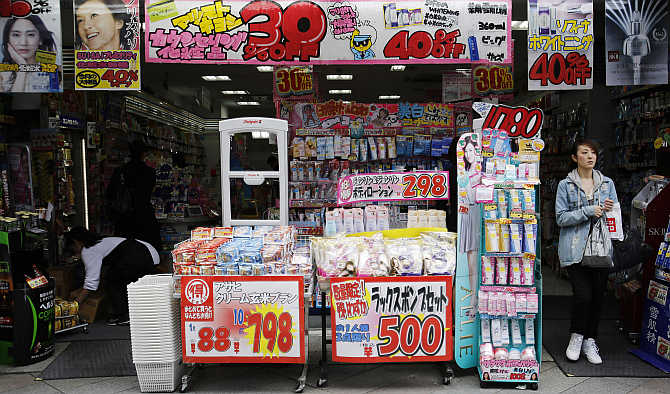 A woman walks out of a drugstore in Tokyo, Japan.