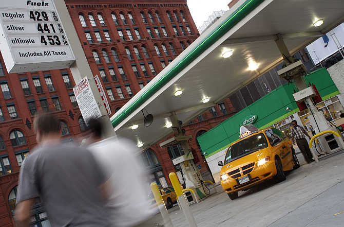 A man pumps petrol into his taxi in New York.