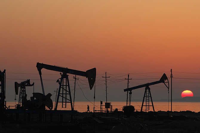 Oil derricks are silhouetted against the rising sun on an oilfield in Baku, Azerbaijan.