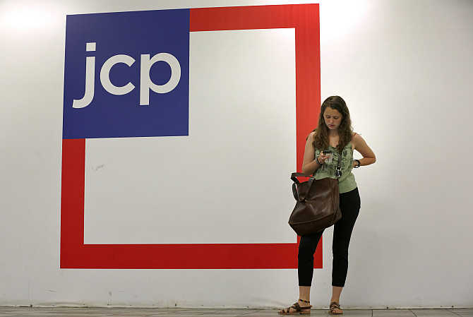 A woman checks her phone outside the entrance of a JC Penney store in New York.