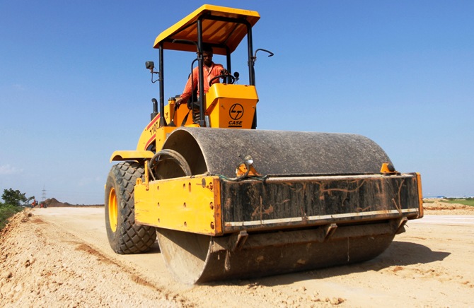 A worker drives a road-roller during road construction near the proposed Ford car plant in Sanand, Gujarat state, September 26, 2011.
