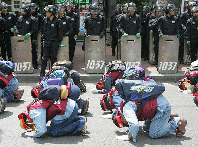 Workers from the Ulsan Construction and Plant Union bow every three steps during a march in Seoul, South Korea. About 600 members of the union and their supporters rallied to demand better working conditions.