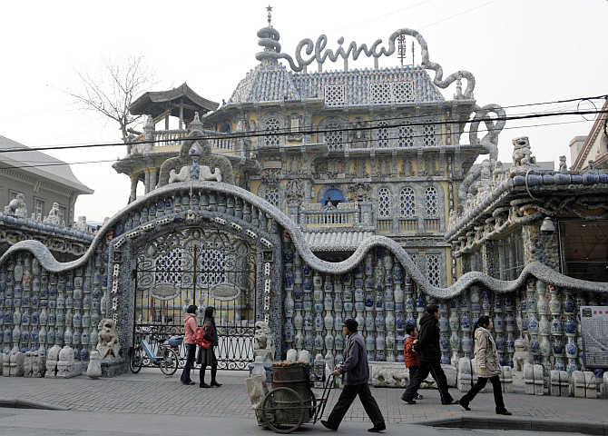 People walk outside the 'China House' in Tianjin, China. The house is decorated with hundreds of millions of ancient porcelain flakes, ancient bowls, dishes and vases, inlaid everywhere in the architecture.
