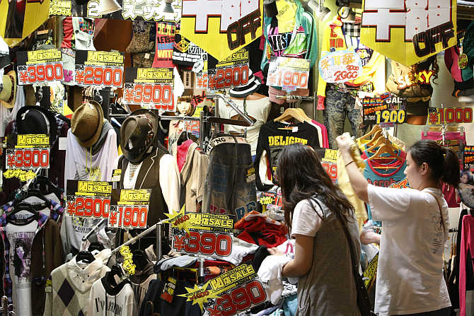 Shoppers browse at a clothing store in the Dotonbori shopping and amusement district in Osaka, Japan.