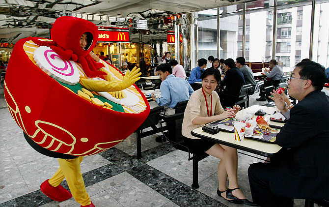 A man dressed as a bowl of noodles greets office workers as he promotes a food fair at a shopping mall in Hong Kong.