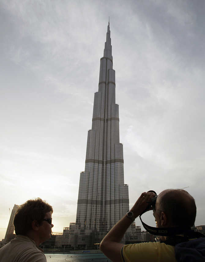 A tourist takes photographs of Burj Khalifa, the world's tallest tower, in Dubai, United Arab Emirates.