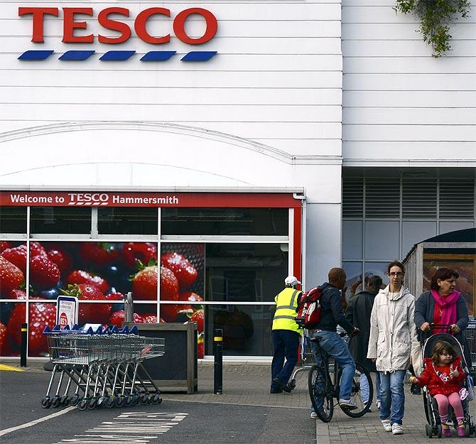 A customer leaves a Tesco store in Hammersmith, west London.